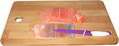 �oso�, filet z �ososia norweskiego, sk�ra z �ososia, ostry n� do filetowania, drewniana deska kuchenna do krojenia, ostry fioletowy n� kupiony w sklepie biedronka