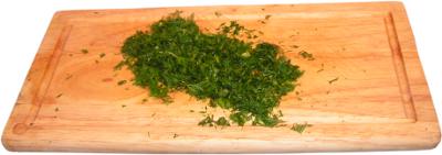 posiekany koperek, drewniana deska do krojenia
